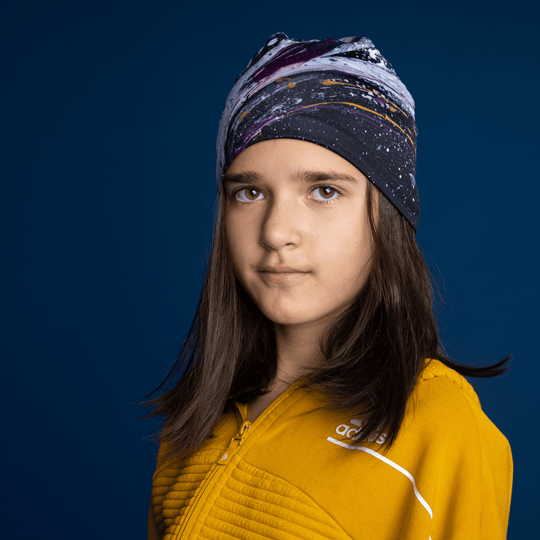 Jeune fille portant la tuque Abracadabra comme bandeau, révélant le motif artistique abstrait.