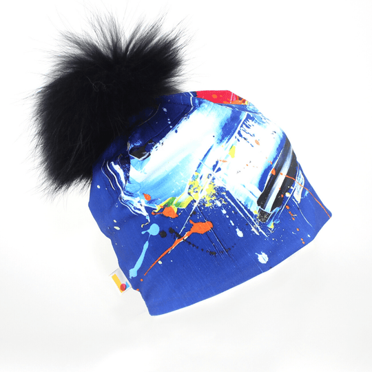 Tuque Bleue Abstrait avec un gros pompon noir et moelleux sur fond blanc.