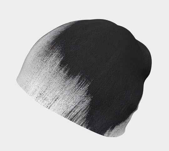 Gros plan du motif abstrait noir et blanc de coups de pinceau sur une tuque grise.
