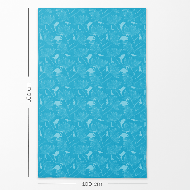 Verso de la serviette de plage Blu XL de Lalita's Art Shop, dans les tons de bleu éclatant, rappelant le bleu de la mer des tropiques, avec des images de flamingo et de fleurs tropicales