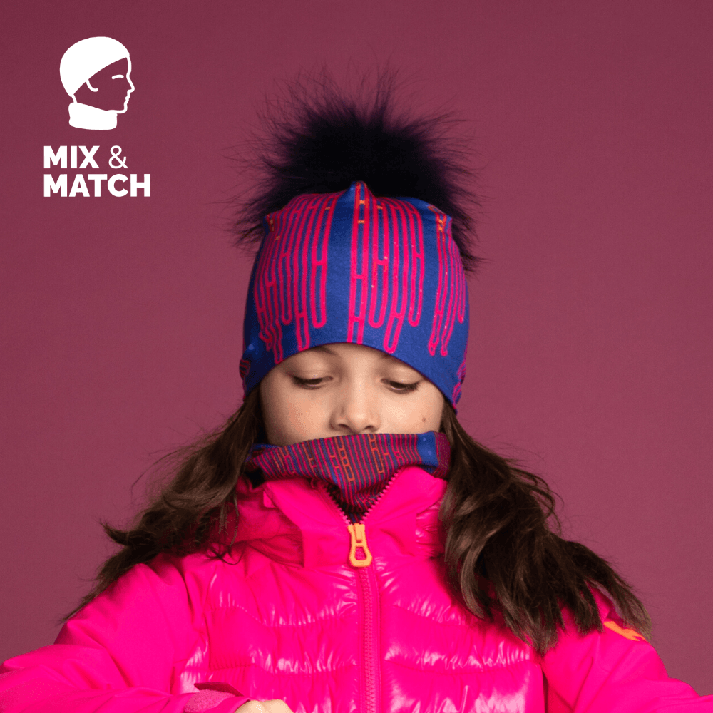 Jeune fille portant la Tuque Blue Loops et un cache-cou assorti, sous une veste rose.