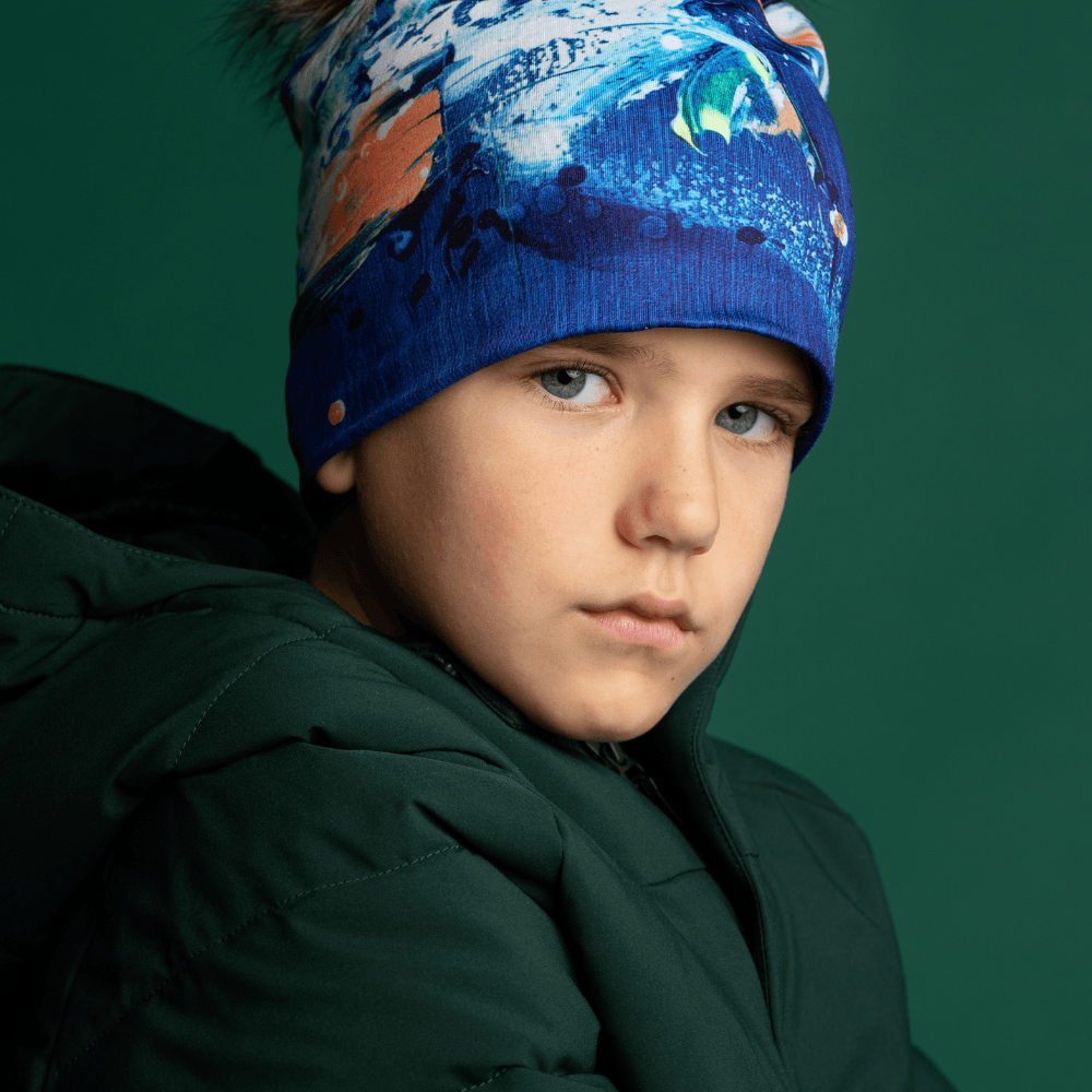 Gros plan d'un jeune garçon portant la tuque abstraite bleue, regardant devant.