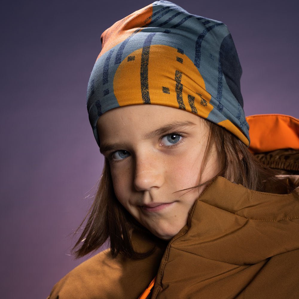 Enfant en manteau brun matelassé regardant droit vers l&