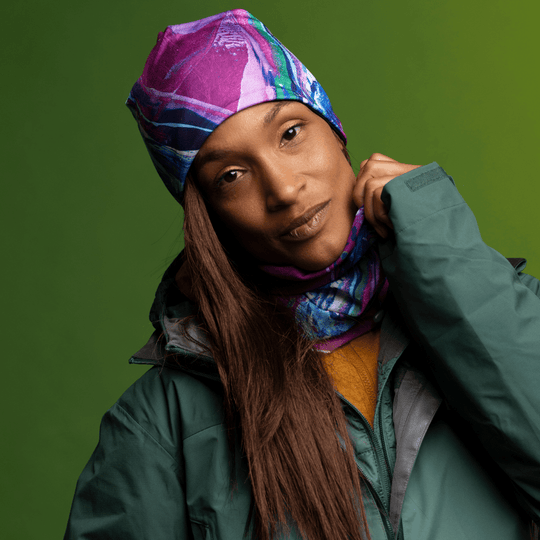 Mannequin féminin portant la Tuque Espoir et son cache-cou coordonné, ajustant la partie écharpe.