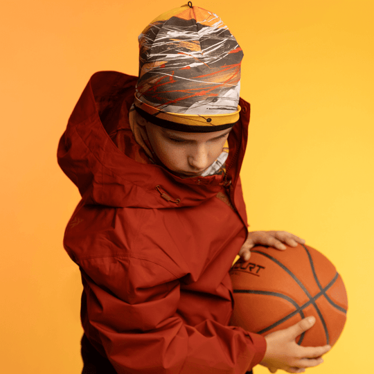 Two young people wearing the Le Coeur Beanie and neck gaiters in a studio setting.