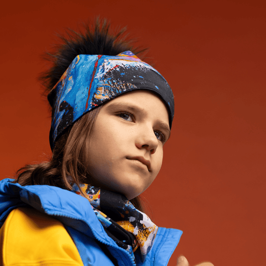 Une jeune personne portant la tuque MatriX et le cache-cou assorti, regardant sur le côté avec une expression pensive.