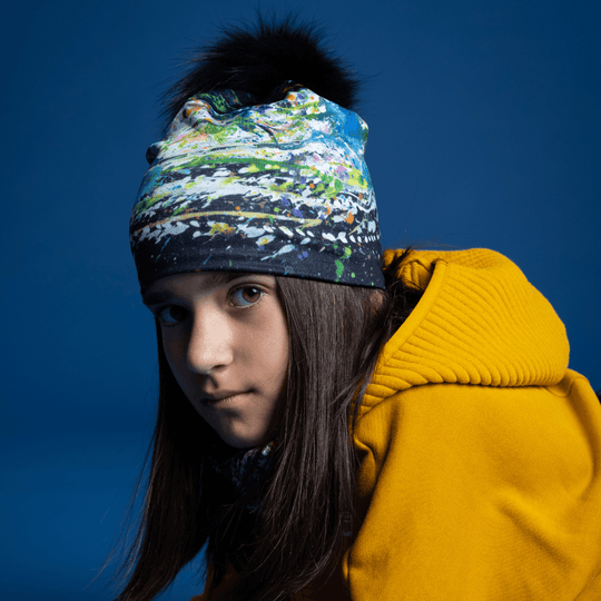 Jeune fille portant la tuque Méduse avec art abstrait et pompon noir.
