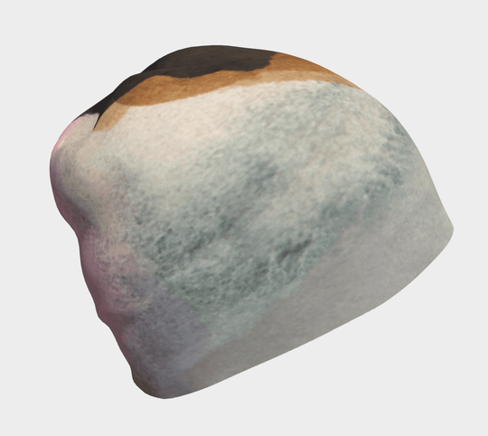 Close-up of a relaxed fit beanie with abstract navy, white, and tan color blocking.