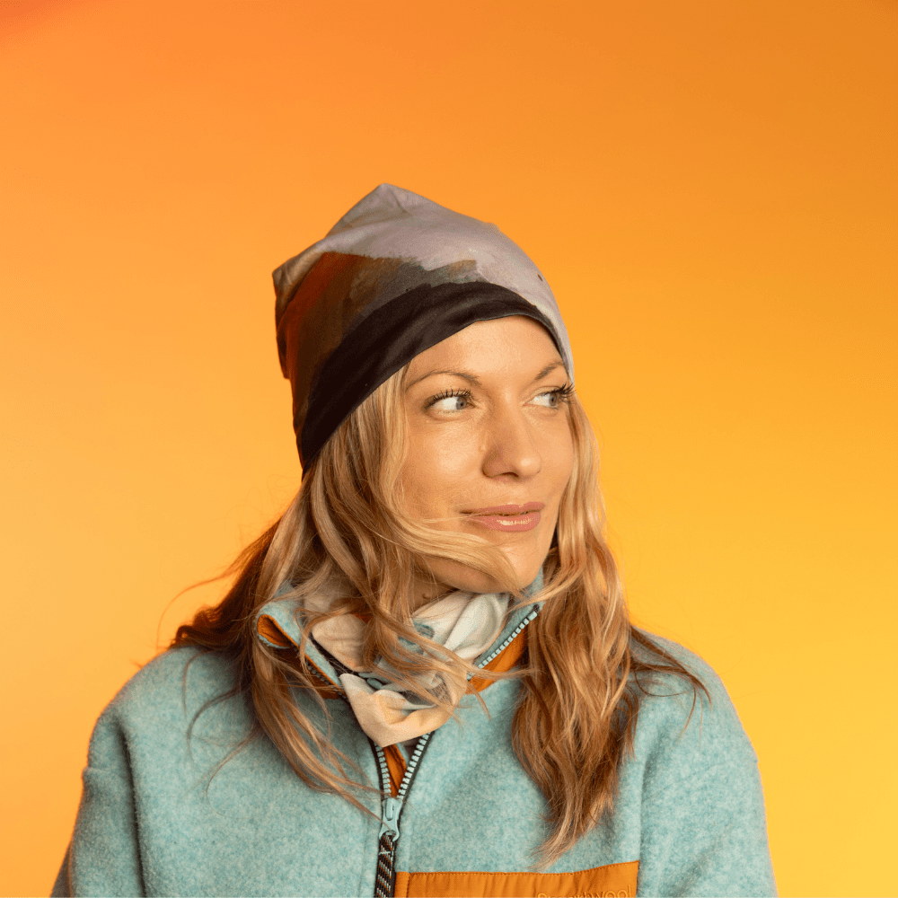 Woman wearing a beanie with abstract navy and grey art print with a matching scarf.