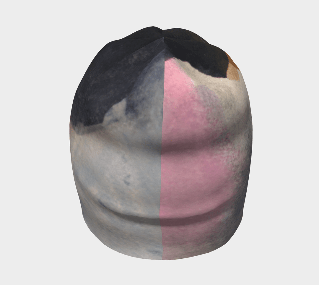 Front view of a relaxed fit beanie with a split design showing abstract art on one side and a pink accent on the other.