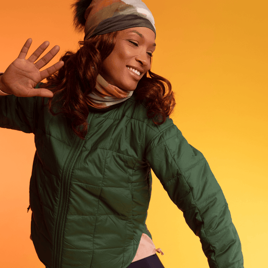 Woman wearing the Navy Accent Beanie With Detachable Pompom dances with a hand raised.