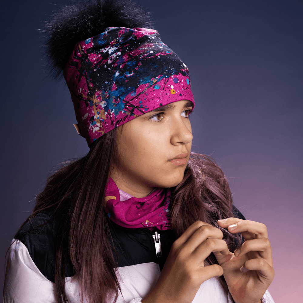 Adolescente portant une tuque rose et noire à art abstrait et une cache-cou rose assortie.