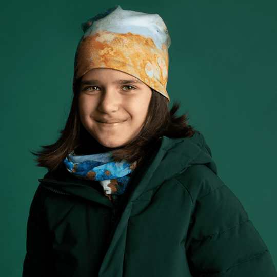 Une jeune fille portant la Tuque Marbre Océan et cache-cou assorti avec un manteau d&