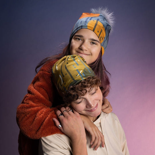 Deux jeunes portant des tuques aux motifs orange et bleu dans un portrait studio chaleureux, style art portée