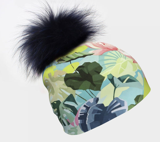 Une tuque colorée Fleurs Pastel avec un grand pompon en fourrure bleu foncé sur fond blanc.