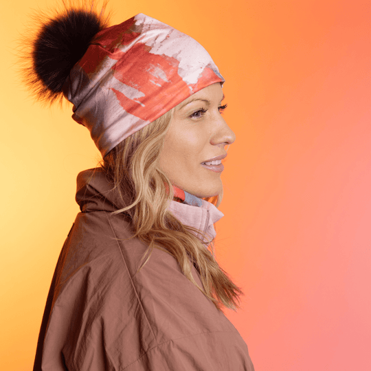Woman wearing the Pink &amp; Flames Beanie with a black pompom in profile.