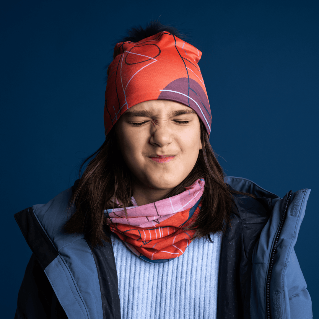 Une jeune fille portant la tuque Graphiques Roses et un cache-cou, faisant une grimace.