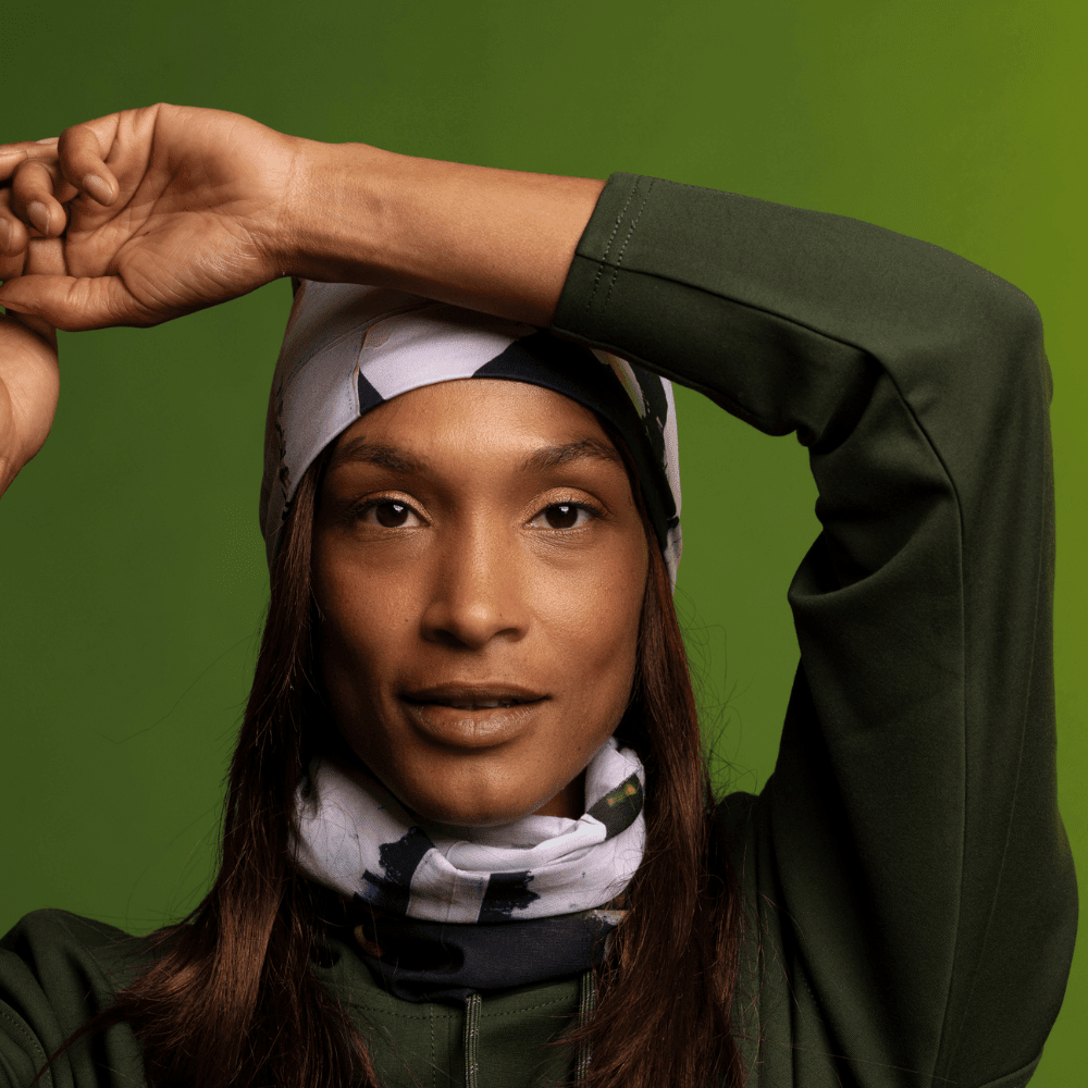 Woman wearing the POLAR Modern Quilt Multifunctional Tube as a beanie and neck scarf, styled with a green hoodie.
