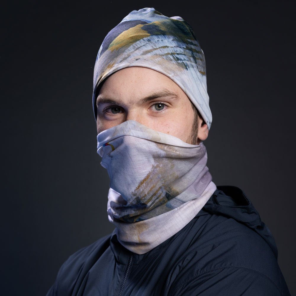 Man wearing a navy jacket, with the abstract art print fabric as a face mask and beanie.