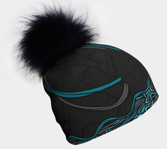 Tuque à motif noir et bleu avec un grand pompon noir moelleux sur fond blanc.