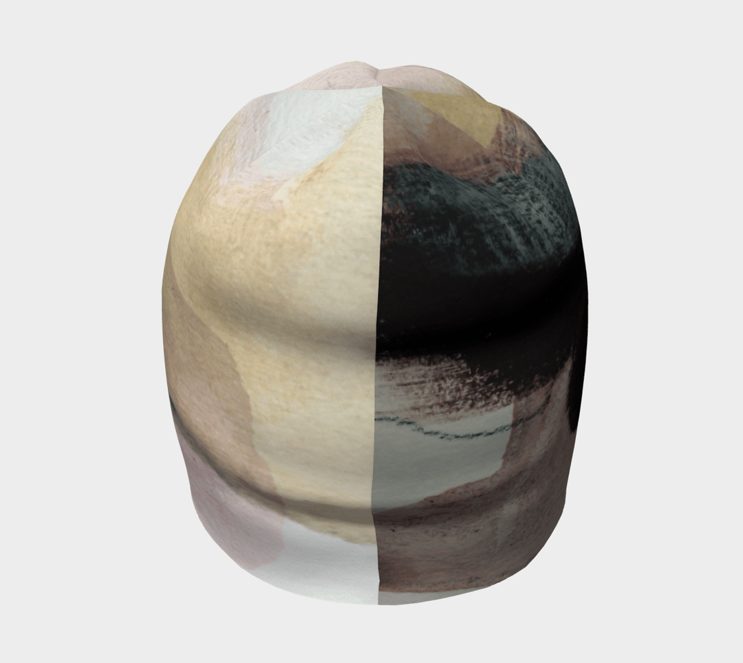 Vue de face de la tuque "Le Nomade Artistique", son motif divisé montrant des éléments abstraits contrastants.