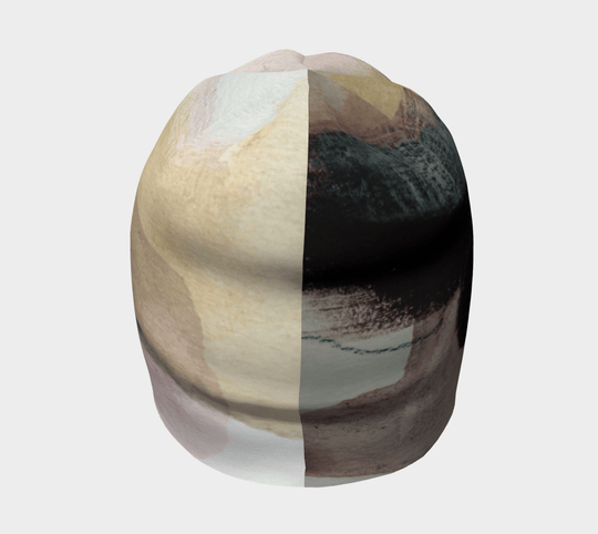Vue de face de la tuque "Le Nomade Artistique", son motif divisé montrant des éléments abstraits contrastants.