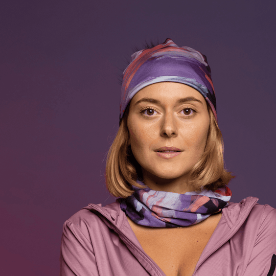 Femme portant la tuque Tulipes et le cache-cou assorti, stylisée avec une veste à capuche rose.
