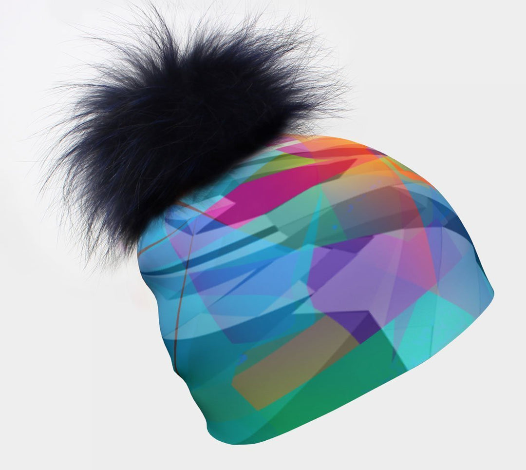 Gros plan d'une tuque unisexe Fast Triangles bleue avec un grand pompon floconneux bleu foncé sur fond blanc.