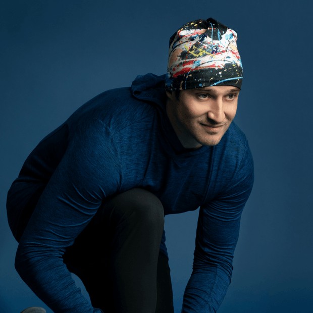 Man wearing the black, white, yellow, blue and a touch of red bamboo tuque with a dark blue blue shirt to go running. 