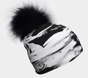 Picture of B&W Beanie. This unisex toque has abstract, elegant and modern black and white patterns with a detachable black pompom and will match all your looks and activities. Finally, the perfect marriage between an original and trendy look with the tech features of sports hats!