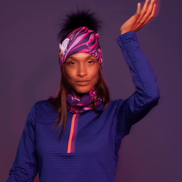 Woman wearing the Magenta Owl multifunctional tube with the assorted pompom beanie by Julie Rocheleau for Lalita's Art Shop.