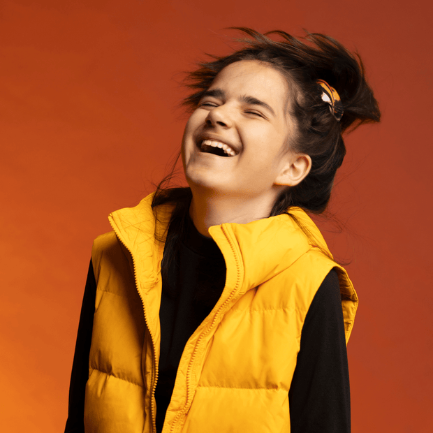 Sportive girl laughing and wearing the Orange Owl Multifunctional tube as a scrunchie for the Lalita's Art Shop 24 collection