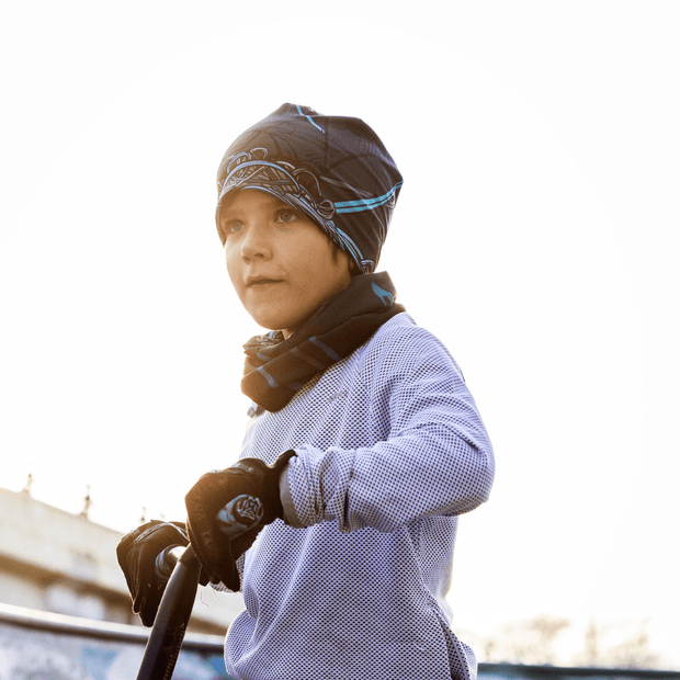 Boy riding a scooter wearing a hat beanie designed by André Martel. This midseason bamboo beanie is ideal for sports and outdoor activities