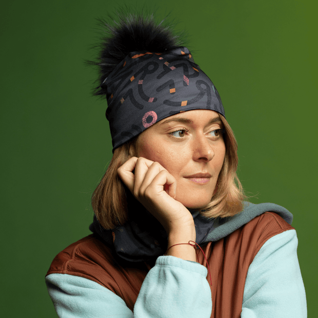 Woman wearing the Black Pompom Symetrick Gray Beanie and assorted multifunctional tube for Lalita's Art Shop