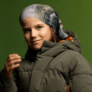 Young boy wearing the Gray and Green Wall multifunctional bandana by Elise Charette for the Lalita's Art Shop 24 collection